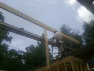 Carpenter setting a ridge beam over a new addition frame — Ice Dam Removal by Roofing Brothers in Farnhamville