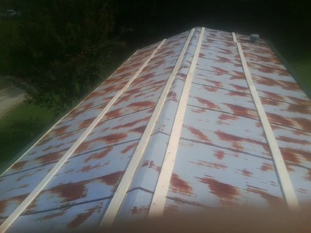 Rusted metal roof panels with new wood purlins before replacement — Storm Damage Roof Repair in Farnhamville by Roofing Brothers