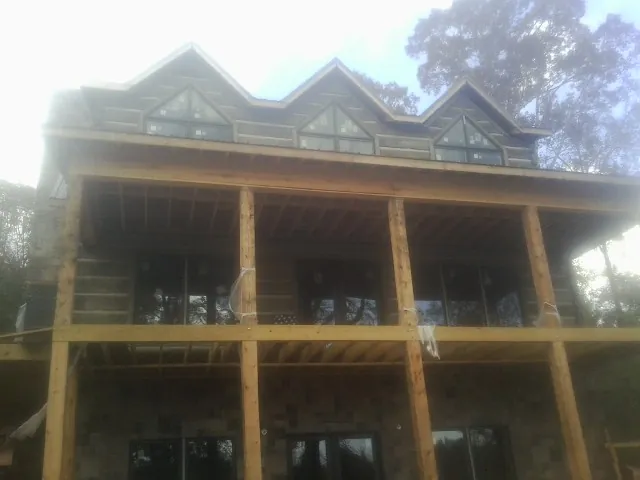 Dormers and porch framing on a large log home under construction — Roof Coating work by our crew in Farnhamville