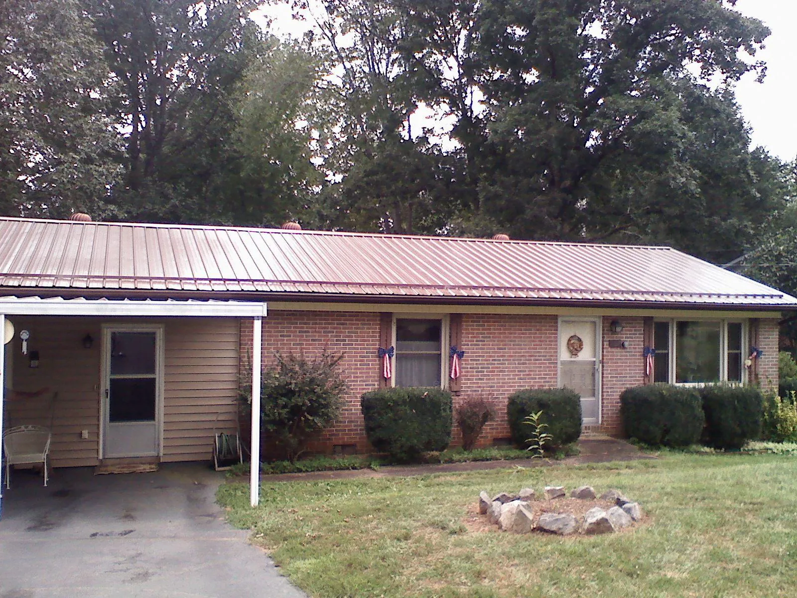 Bronze metal roof and carport on a brick ranch home — Roof Repair work by our crew in Farnhamville